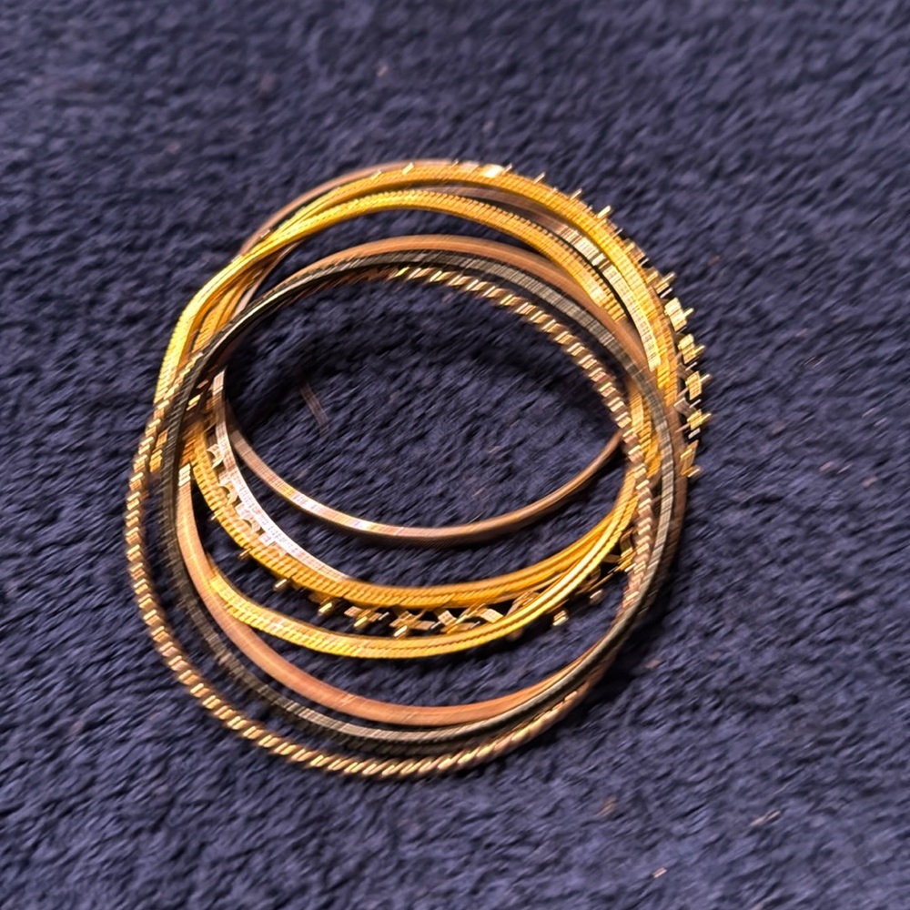 Bundle of gold and black bracelets.